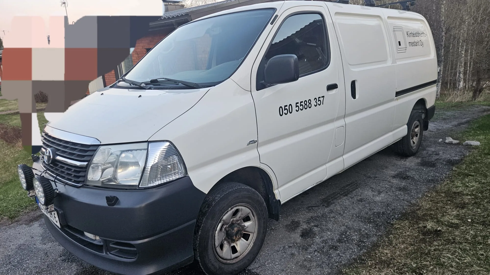 Valkoinen KHM-pakettiauto pihassa